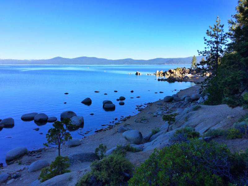 While hiking last Sunday with a friend (and the Girl), we were presented with this gorgeous view of an early-morning Lake Tahoe, with the sun just peaking over the edge of the rim crest to illuminate the point at Chimney Beach.