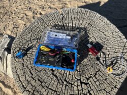 Everything that is needed to operate on four of the high frequency amateur radio bands is in or next to this box. There is a radio, the Sagebrush antenna, a battery, headphones, and a couple of Morse Code keys.